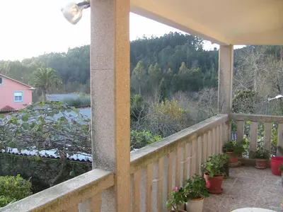 a balcony with potted plants and a view of a house at Casa Xan da Pena in Villarmayor