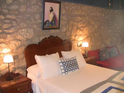 a bedroom with a bed and two night tables with lamps at Casa Xan da Pena in Villarmayor