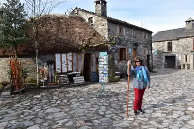 a woman holding a stick in front of a building at Stone Cottage FISTERRA in Curtis