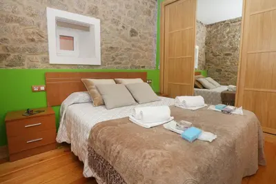 a bedroom with a large bed with towels on it at A Casa do Avó in Palas de Rei