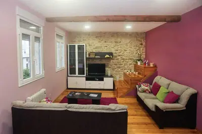 a living room with two couches and a brick wall at A Casa do Avó in Palas de Rei