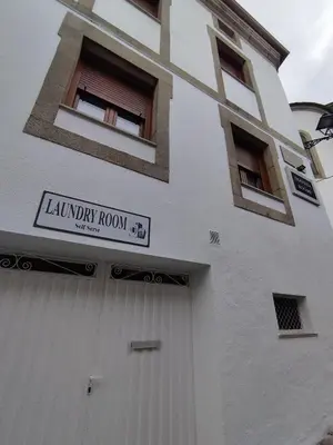 a white building with a library room sign on it at Travesia Rooms in Sarria