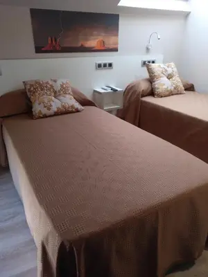 a room with two beds and a couch at Travesia Rooms in Sarria