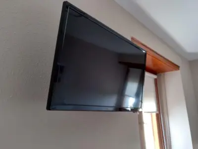 a flat screen tv hanging on a wall at Travesia Rooms in Sarria