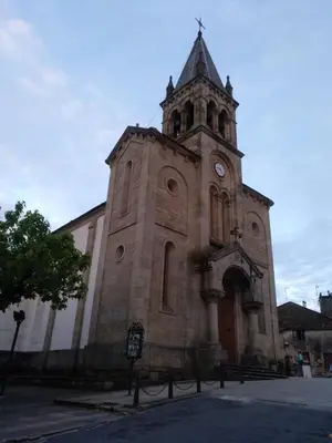 a church with a tower with a clock on it at Travesia Rooms in Sarria