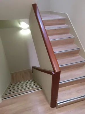 a stairway with a wooden rail and a stair case at Travesia Rooms in Sarria