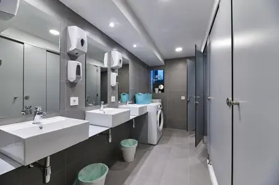 a bathroom with two sinks and a washing machine at Albergue San Francisco in Arzúa