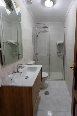a bathroom with a sink and a shower and a toilet at Hotel Pousada Vicente Risco in Castro Caldelas