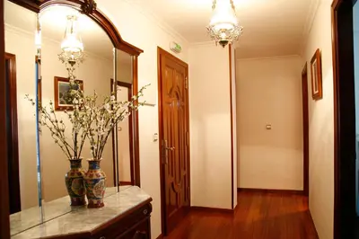a hallway with two vases on a table with a mirror at Hotel Pousada Vicente Risco in Castro Caldelas