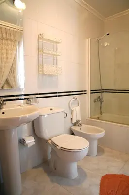 a white bathroom with a toilet and a sink at Hotel Pousada Vicente Risco in Castro Caldelas