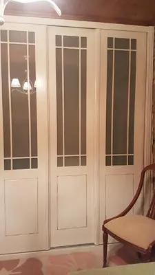 a cabinet with glass doors in a room with a chair at Casa Santiago in Currelos