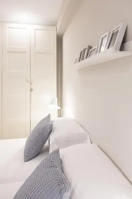 a bedroom with a white bed with blue pillows at Apartamento de diseño centrico con terraza espectacular in Santiago de Compostela