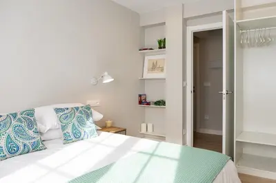 a bedroom with a white bed with blue pillows at Apartamento de diseño centrico con terraza espectacular in Santiago de Compostela