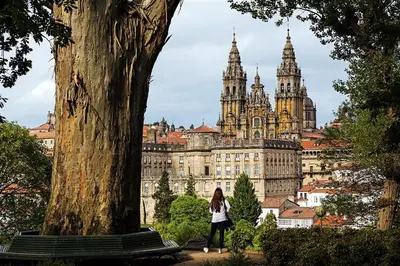 a woman standing next to a bench in front of a building at Apartamento de diseño centrico con terraza espectacular in Santiago de Compostela