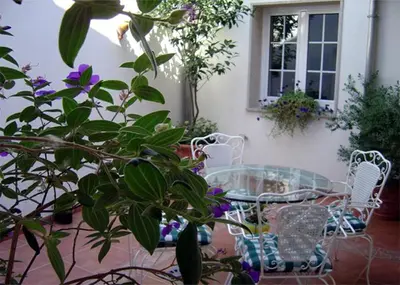a patio with a table and chairs and flowers at Hostal Alfonso in Santiago de Compostela