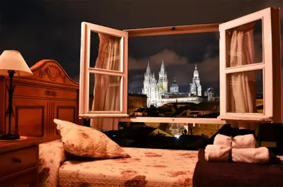 a bedroom with a window with a view of the castle at Hostal Alfonso in Santiago de Compostela