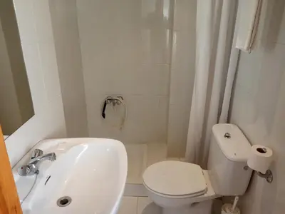 a white bathroom with a toilet and a sink at Hostal Mobydick2 in Ourense