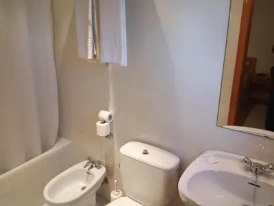 a white bathroom with a toilet and a sink at Hostal Mobydick2 in Ourense