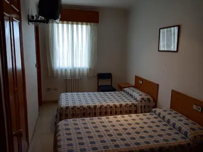 a hotel room with two beds and a television at Hostal Mobydick2 in Ourense