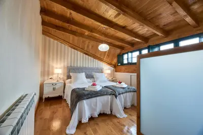 a bedroom with two beds in a room with wooden ceilings at Casa Entera A Ferradura in Melide