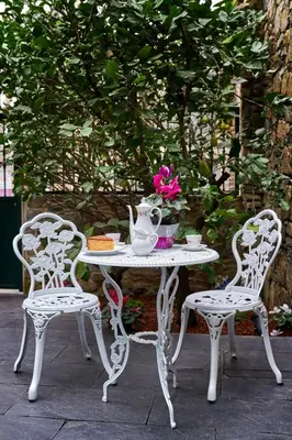 a white table and two chairs with a vase on it at Casa Entera A Ferradura in Melide