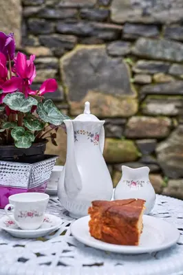 a table with a plate of cake and a vase at Casa Entera A Ferradura in Melide