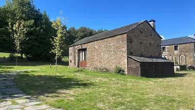 an old brick building in a field next to a road at Casas do Campo in Monfero