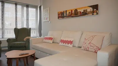 a living room with a white couch and a chair at Apartamento Vía Romana XIX in Lugo