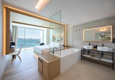 a hotel room with a bed and a tub and a bathroom at Noa Boutique Hotel in Santa Cruz de Oleiros