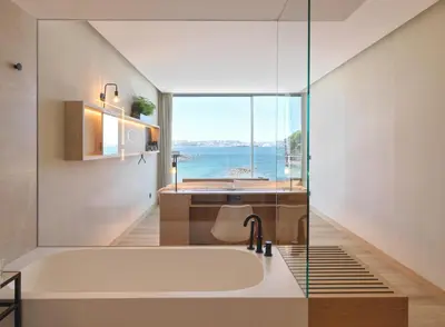 a bath tub in a bathroom with a view of the ocean at Noa Boutique Hotel in Santa Cruz de Oleiros