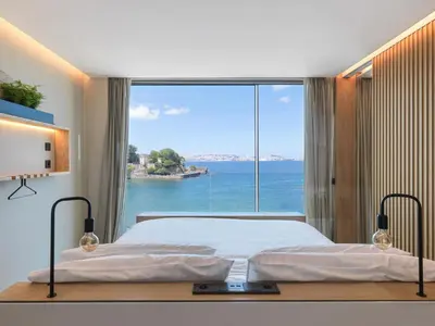 a bedroom with a bed and a large window at Noa Boutique Hotel in Santa Cruz de Oleiros