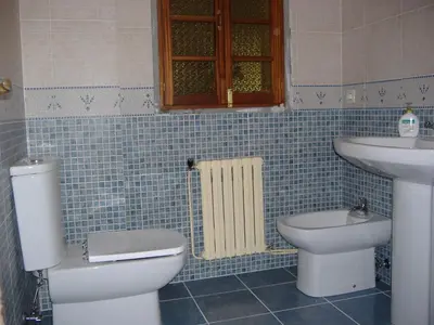 a blue tiled bathroom with a toilet and a sink at CHALT EN MIÑO CON VISTAS AL MAR in A Coruña