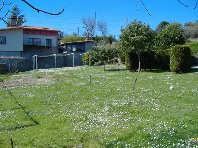 a field of grass with white flowers in front of a house at CHALT EN MIÑO CON VISTAS AL MAR in A Coruña