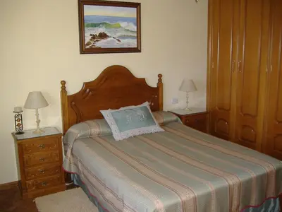 a bedroom with a bed with two night stands and two lamps at CHALT EN MIÑO CON VISTAS AL MAR in A Coruña