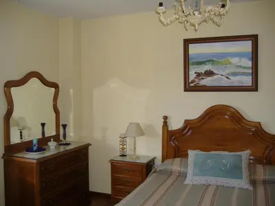 a bedroom with a bed and a dresser and a mirror at CHALT EN MIÑO CON VISTAS AL MAR in A Coruña