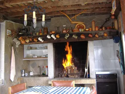 a kitchen with a fireplace and a table with a fire at CHALT EN MIÑO CON VISTAS AL MAR in A Coruña