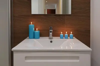 a bathroom sink with three blue candles on it at Estación de tren by Como en Casa in Santiago de Compostela