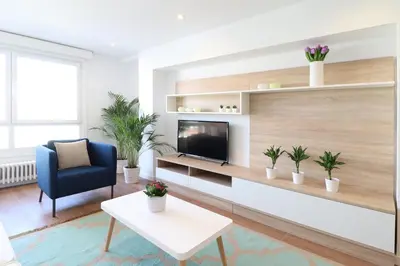 a living room with a tv and a blue chair at Estación de tren by Como en Casa in Santiago de Compostela