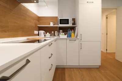 a kitchen with white cabinets and a white refrigerator at Estación de tren by Como en Casa in Santiago de Compostela