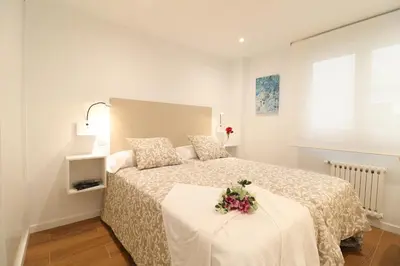 a bedroom with a bed with a flower arrangement on it at Estación de tren by Como en Casa in Santiago de Compostela