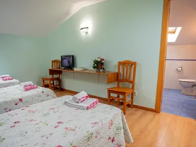 a room with two beds and a bathroom with a toilet at CASA CINES in Lugo
