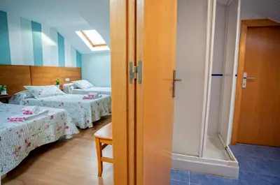 a bedroom with two beds and a walk in shower at CASA CINES in Lugo