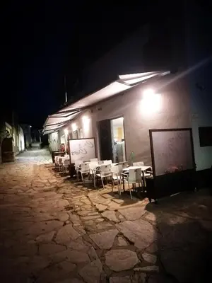 a group of tables and chairs outside of a building at night at CASA CINES in Lugo