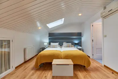 a bedroom with a large bed with a yellow blanket at Berce in Arzúa