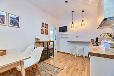 a kitchen and living room with white walls and wooden floors at Berce in Arzúa