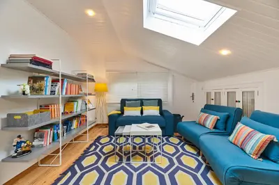 a living room with blue couches and a book shelf at Berce in Arzúa