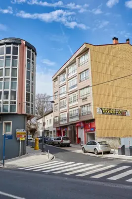 a building on a street with cars parked in front of it at Berce in Arzúa