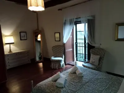 a bedroom with a bed with two chairs and a window at Palacio de Cantiz 