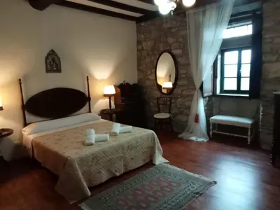 a bedroom with a bed and a table and a mirror at Palacio de Cantiz 