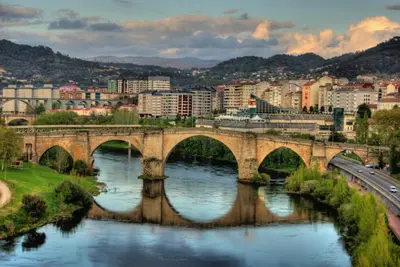 a bridge over a river in a city at Apartamento en el centro de Ourense in Ourense